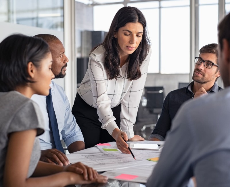 The woman explains something on a piece of paper to her work colleagues.